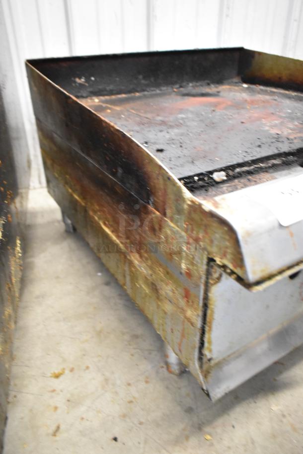 Cooking Performance Group stainless steel commercial flat top griddle, gas powered, used condition, visible grease and rust.