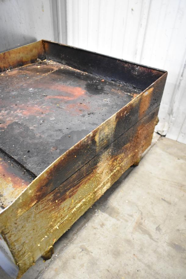 Cooking Performance Group stainless steel commercial gas flat top griddle, worn condition, visible rust and grease marks.