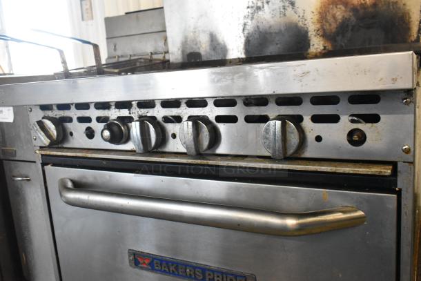 Bakers Pride stainless steel 6-burner gas range with oven, overhead shelf, and backsplash. Visible wear, functional knobs.