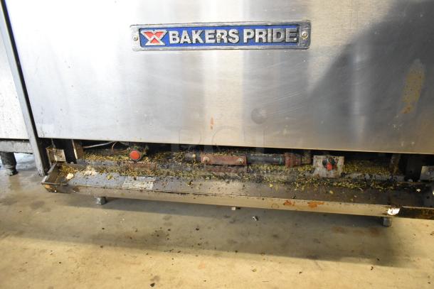 Bakers Pride stainless steel 6-burner gas range with oven. Features over shelf, back splash. Visible wear and debris buildup.