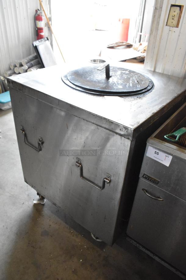Stainless steel gas-powered commercial tandoor oven on casters, floor style, with sturdy handles, moderate wear.