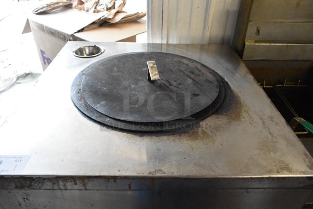 Stainless steel commercial gas tandoor oven on casters, circular lid, used condition, visible wear marks.