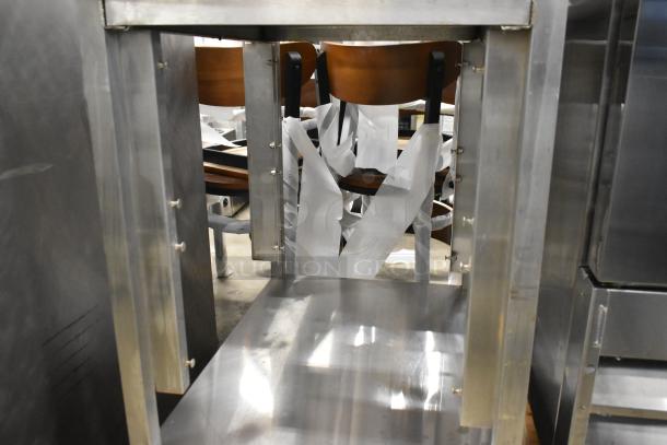 Stainless steel equipment stand with under shelf, featuring sturdy frame and polished finish, in good condition.