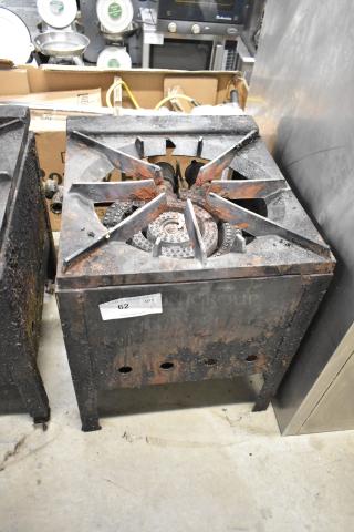 Metal commercial gas-powered stock pot range with single burner, visible signs of rust and wear, auction tag "62" attached.