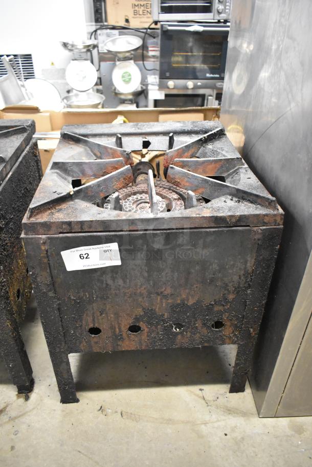 Metal commercial gas-powered single burner stock pot range with visible rust and wear, tag marked "62 QTY 1."