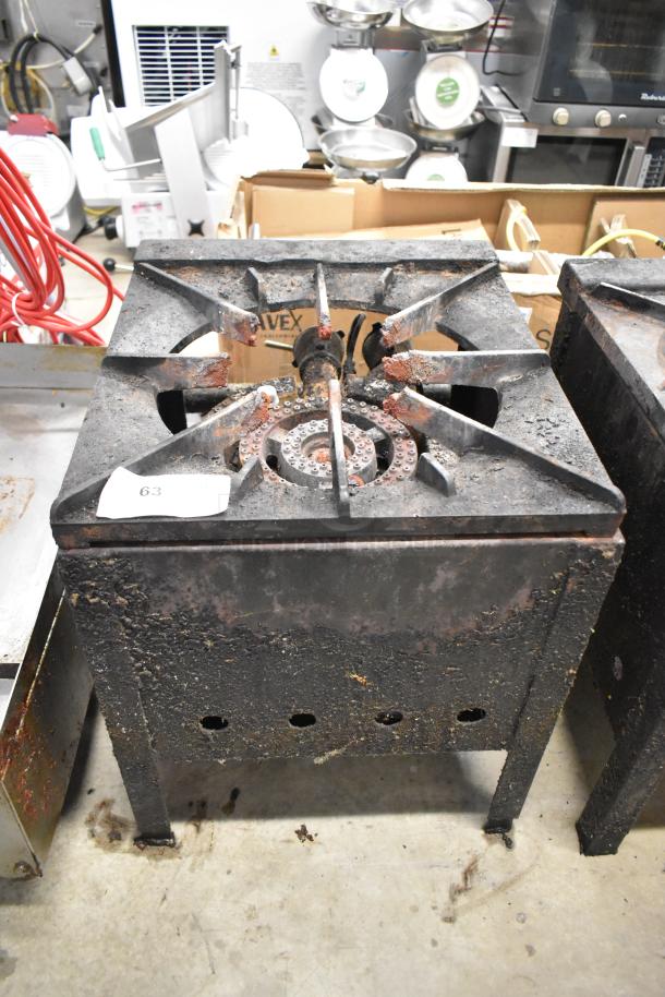 Metal commercial gas-powered single burner stock pot range, visible surface wear, rust on burner, label "63".
