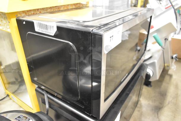 Frigidaire EMW1120-B-3ACOM stainless steel countertop microwave oven with visible barcode and auction label. 120V, 1 phase.