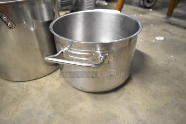 Three stainless steel stock pots, varying sizes, solid handles, gently used condition, ideal for bulk cooking.