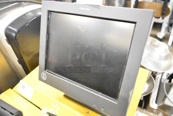 Toshiba monitor with visible wear, part of auction lot including IBM monitor and credit card reader; bid multiplies by 3.