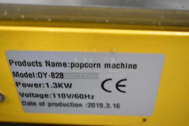 2019 OY-828 metal countertop popcorn machine, 110V, 1.3KW. Label shows model, power, and production date. CE marked.