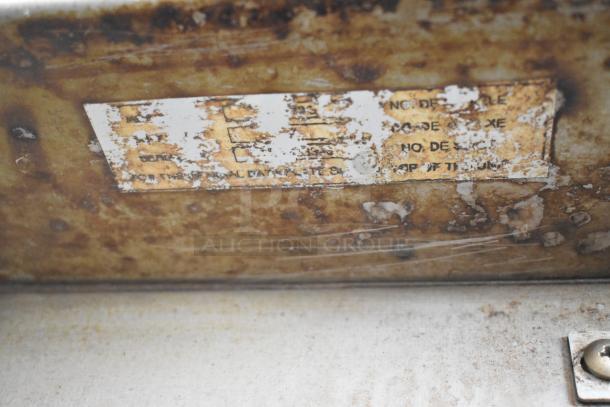 Baxter stainless steel commercial oven label, showing wear and partially obscured text.