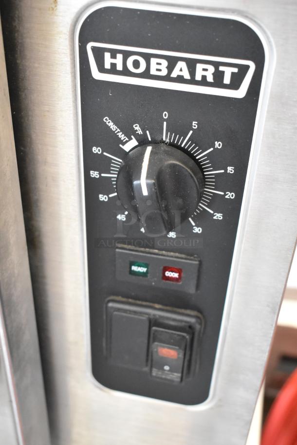 Hobart HC24EA5 steam cabinet control panel close-up, showing dial settings and indicator lights on stainless steel surface.