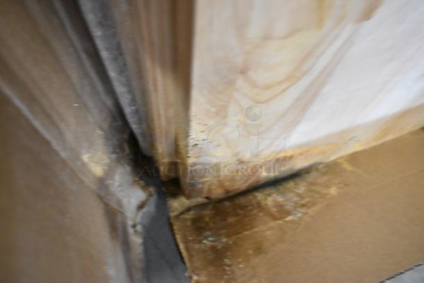 Wooden under shelf cover with visible water damage and mold, showing wear and discoloration.