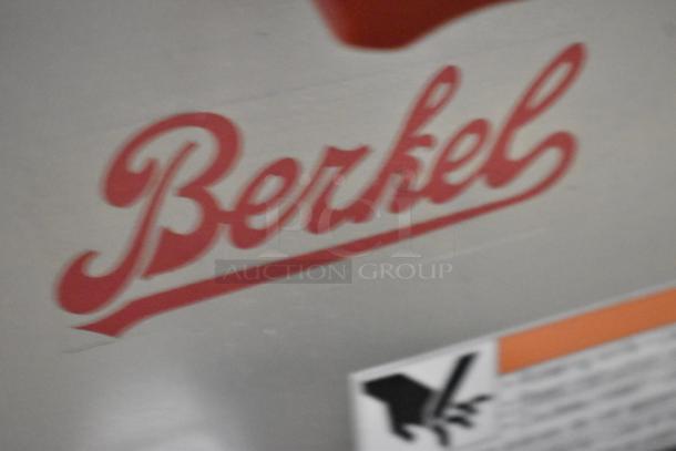 Berkel B9-SLC stainless steel meat slicer with blade sharpener, logo and safety label visible.