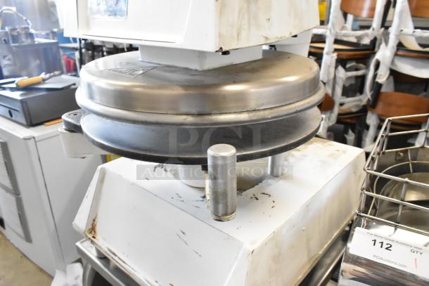 DoughPro metal countertop dough press on stainless steel stand. Used, 115 volts, 1 phase. Visible wear, suitable for commercial use.