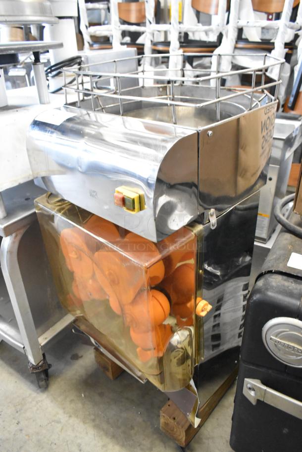 Stainless steel commercial countertop citrus juicer, 115 volts, 1 phase, visible oranges inside, in used condition.
