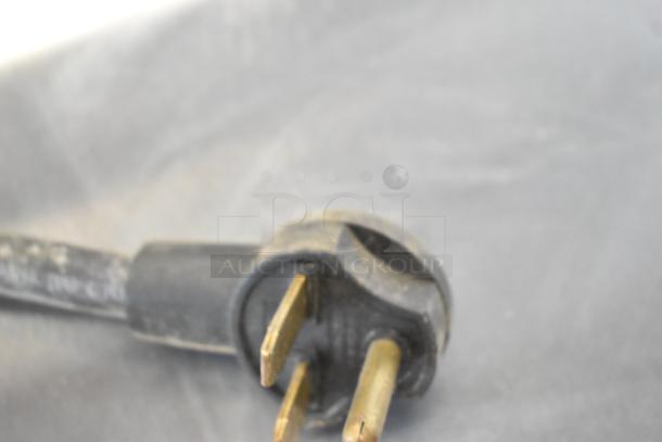 Close-up of a power plug from a Turbochef NGO Rapid Cook Oven, showing three metal prongs.