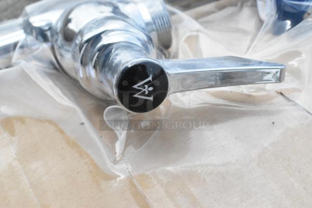 Brand new Waterloo faucet with spray nozzle, in original packaging. Minor scratches visible, logo marked on handle.