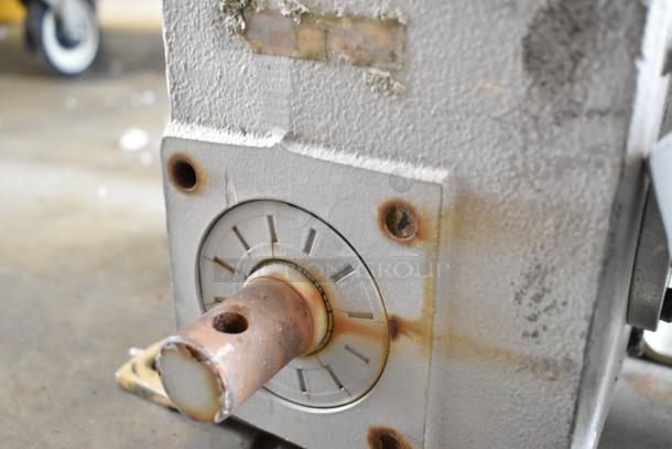 Rusty motor component with visible wear, showing a metal shaft and mounting plate. Lacks visible markings or labels.