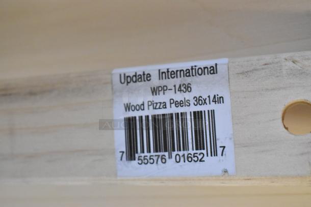 Barcoded label of Update International WPP-1436, 36x14in wood pizza peel, on light wood surface.