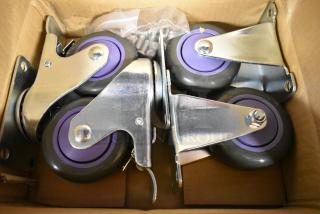 Lot of 4 brand new commercial casters in box; scratch and dent condition with purple wheels and metal brackets.