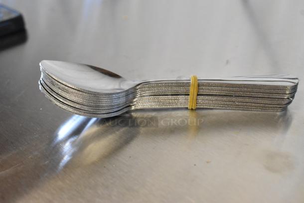 Stack of 4 1/4" Doxen Choice Dominion 18/0 stainless steel demitasse spoons with rubber band, new condition.