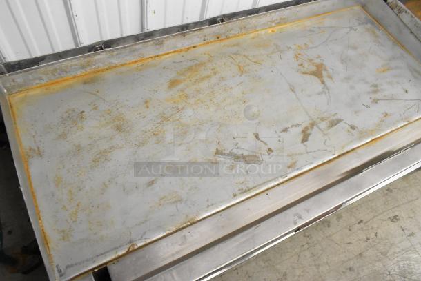 Vulcan stainless steel commercial countertop flat top griddle, showing wear and discoloration, suitable for heavy-duty use.