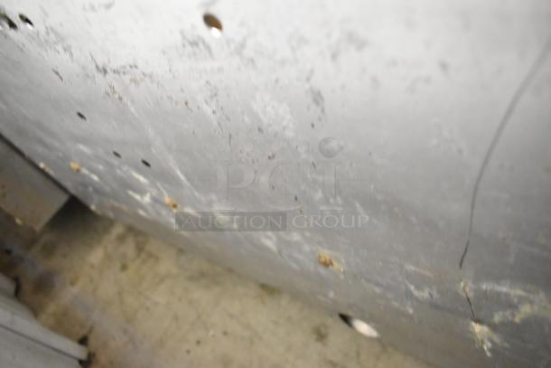 Blurry image of a surface with visible rust spots and discoloration, possibly metal. No identifiable features of a griddle.