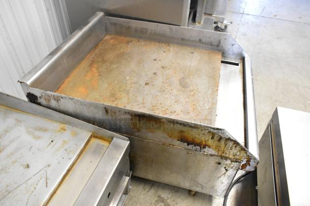 Stainless steel commercial gas griddle with flat top, used condition, visible rust and discoloration on cooking surface.