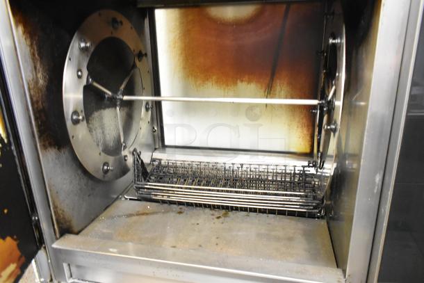 Fri-jado TDR7-P stainless steel rotisserie oven with commercial casters, visible wear and broken glass; 208 volts, 3-phase.