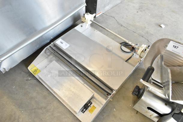 Metal countertop sealing station, 115 volts, 1 phase, stainless steel, with visible warning labels, in good condition.