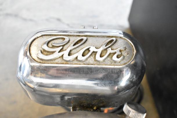 Globe stainless steel commercial meat slicer with blade sharpener. Features "Globe" logo. 115 volts, 1 phase.