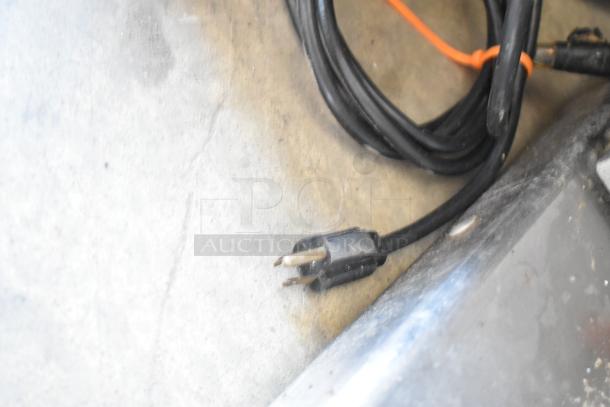 Black power cord with a standard two-prong plug on a countertop.