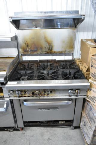 Southbend stainless steel commercial gas range with 6 burners, oven, overshelf, backsplash, and commercial casters.