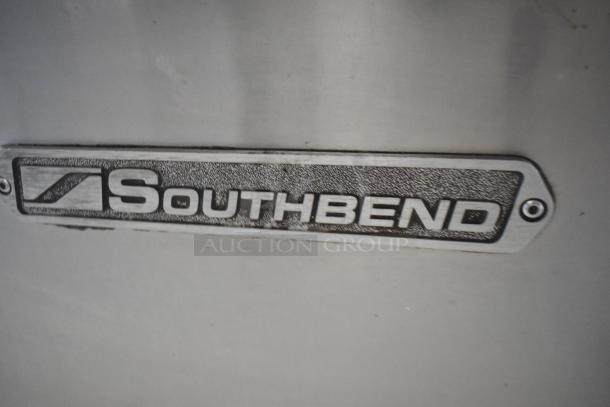 Southbend stainless steel commercial gas-powered 6 burner range with oven, over shelf, backsplash, and casters.