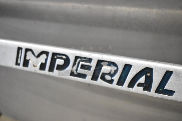 Imperial stainless steel commercial gas range, 6 burners, right-side griddle, 2 ovens, overshelf, backsplash, on casters.