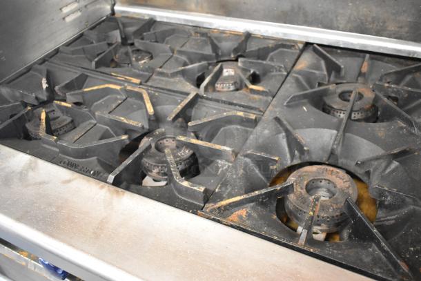 Imperial stainless steel 6 burner gas range with griddle, 2 ovens, overshelf, backsplash, on casters. Visible wear.