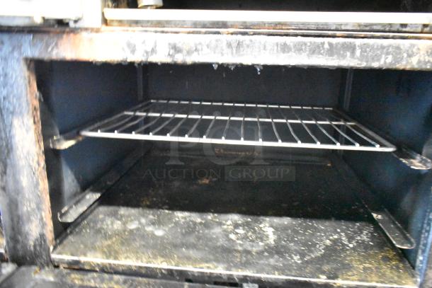 Imperial Stainless Steel Gas Range, 6 burners, right side flat top griddle, 2 ovens, over shelf, backsplash, on casters.