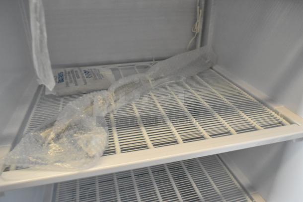 KoolMore KM-FMD12WH commercial reach-in freezer interior, showing metal shelves, new condition, manual defrost.