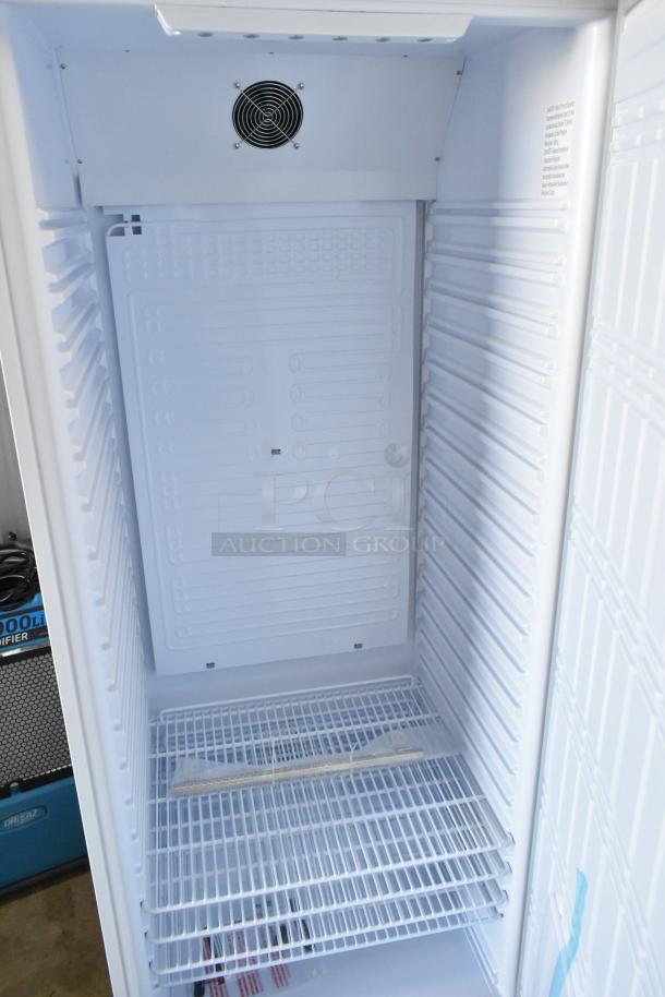 Brand new KoolMore KM-RMD20WH commercial refrigerator interior with metal shelves, 20 Cu. Ft, 115V, 1 Phase, scratch and dent condition.