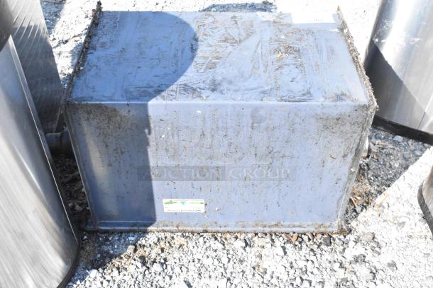 Metal commercial grease trap, used condition with visible wear and rust. Features affixed label indicating model details.