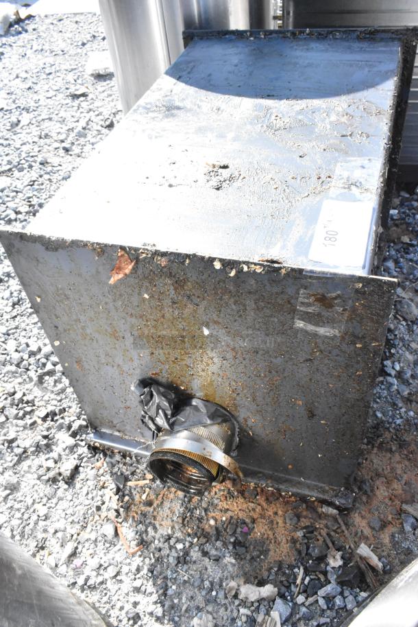 Metal commercial grease trap with visible rust and wear, label indicating it is item "180 KG."