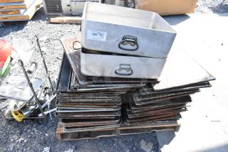 Lot of metal roasting pans and perforated baking sheets, stacked. Visible tag: "183." Used condition.