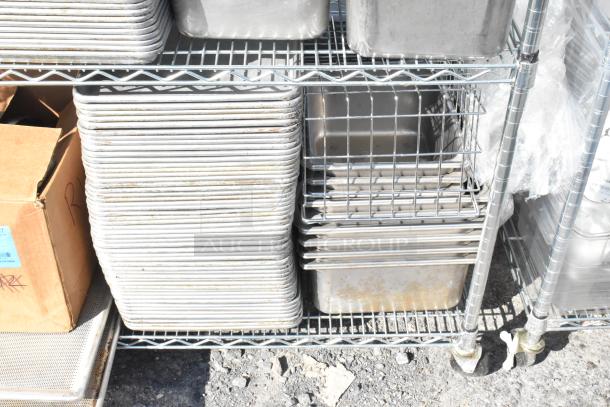 Chrome 4-tier wire shelving unit with stainless steel bins and baking pans. Contents included; dismantling required.