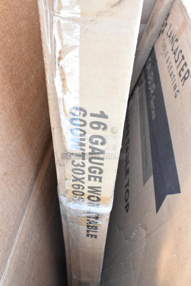Boxes of scratch and dent items including a 16-gauge work table, Regency posts, and tabletop, marked as 600WT 30x60.