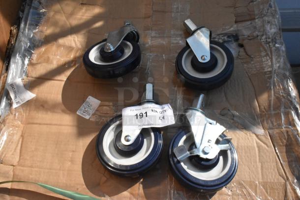 Lot of 4 brand new commercial casters, slight scratches and dents, metal brackets, black and white wheels, auction tag visible.