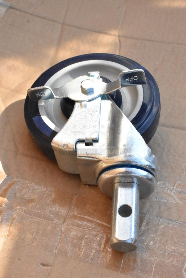 Brand new commercial caster, metal frame, blue wheel, brake lever marked "ON" and "OFF," minor scratches visible.