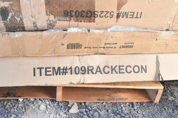 Cardboard boxes labeled "ITEM #109RACKECON" show signs of wear, containing six scratch and dent items, including a patio stove and pan rack.