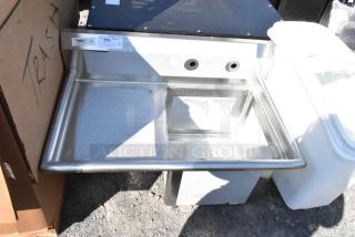 Brand new Regency 600S1181818L stainless steel single bay sink with left side drain board, scratch and dent, no legs. Tags show NSF certification.