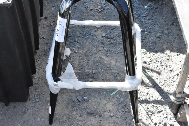 Black metal bucket stool frame, brand new with minor scratches and dents, wrapped in protective material. Auction label visible.